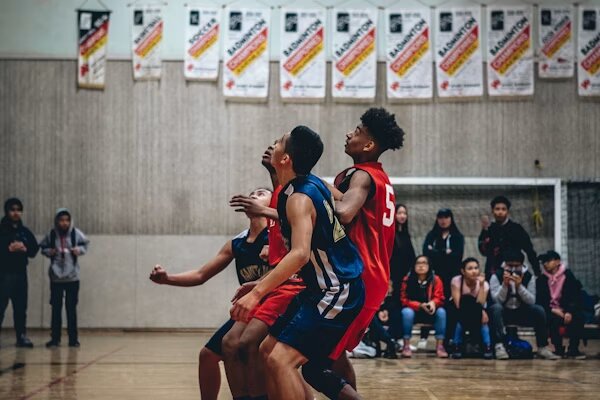 Jugadores disputando un balón en un partido de baloncesto